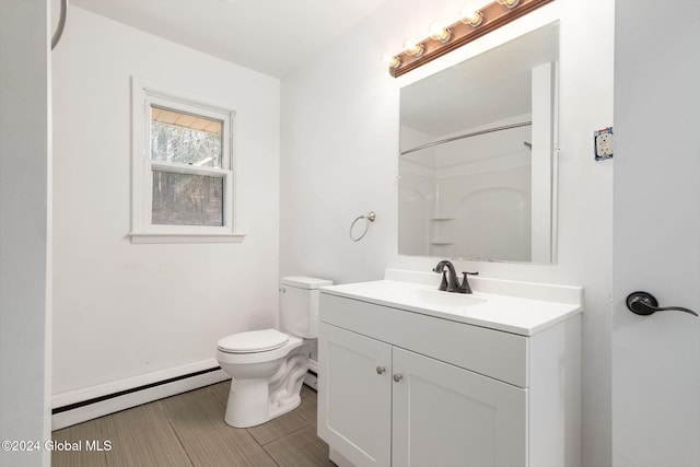 bathroom with a shower, vanity, a baseboard radiator, and toilet