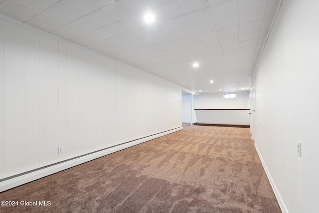 carpeted spare room featuring a baseboard radiator