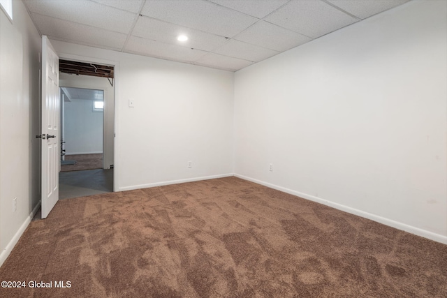 carpeted empty room with a drop ceiling