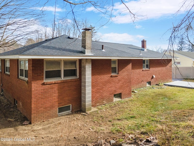 rear view of property with a lawn