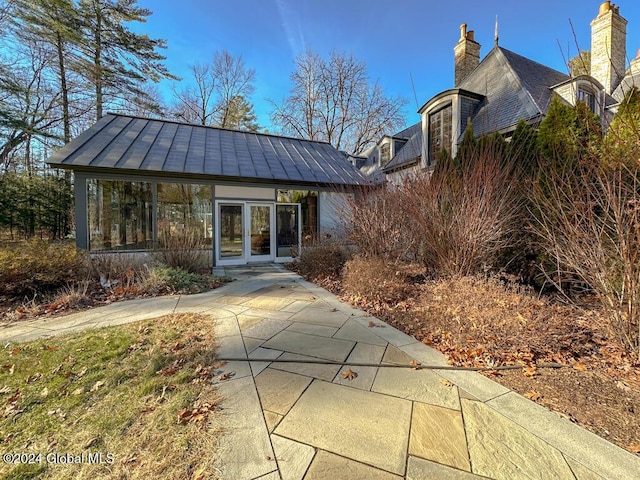 back of property with french doors and a sunroom