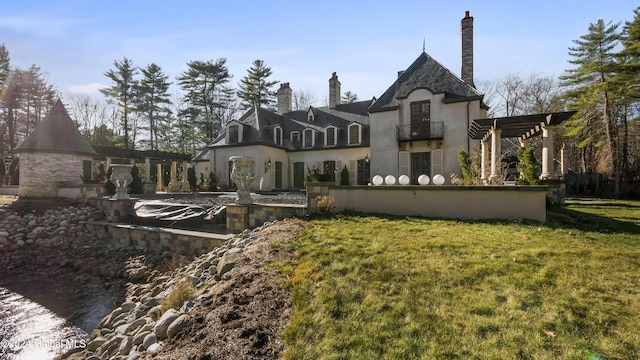 back of property featuring a yard and a balcony