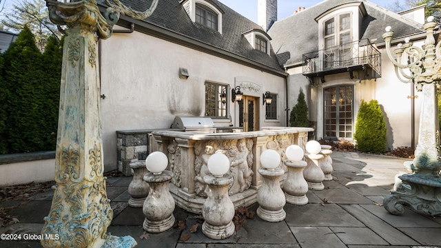 view of patio with area for grilling, a balcony, and grilling area