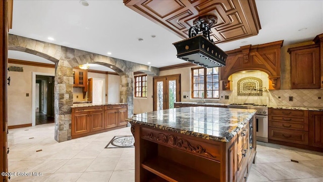 kitchen featuring a center island, dark stone countertops, high end range, and crown molding