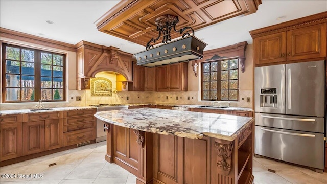 kitchen featuring light stone countertops, sink, a kitchen island, and stainless steel appliances