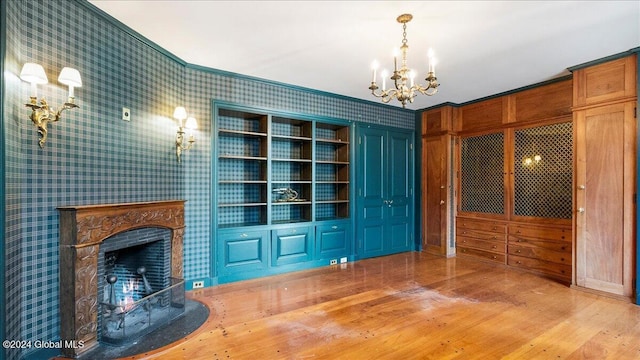 interior space featuring a wood stove, hardwood / wood-style flooring, an inviting chandelier, and crown molding