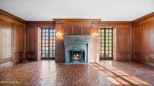 unfurnished living room featuring a wealth of natural light and wood walls