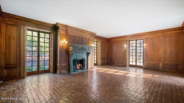 unfurnished living room with wooden walls and crown molding