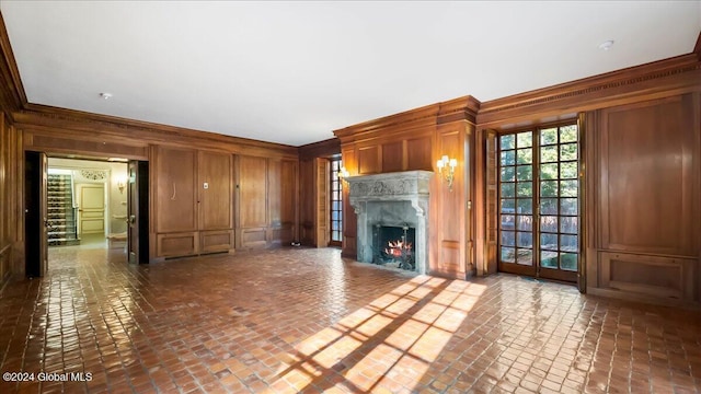 unfurnished living room with crown molding and wooden walls