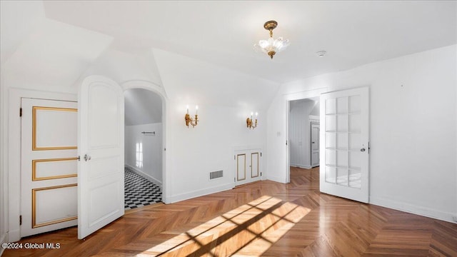 empty room featuring parquet flooring and lofted ceiling