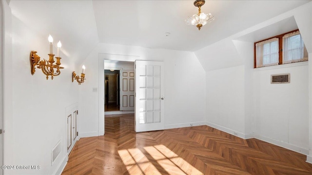 empty room featuring parquet floors and lofted ceiling