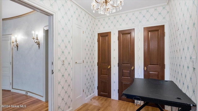 interior space with hardwood / wood-style flooring, ornamental molding, and a chandelier