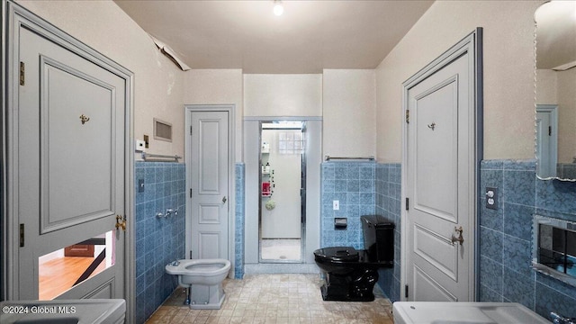 bathroom with tile patterned flooring, a bidet, toilet, and tile walls