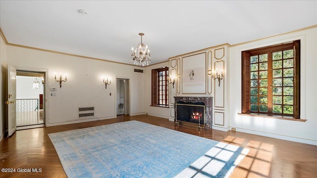 unfurnished living room featuring dark parquet flooring, crown molding, a fireplace, a notable chandelier, and heating unit