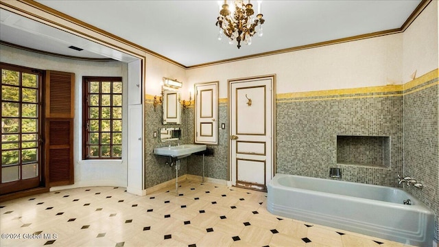 bathroom featuring a notable chandelier, a washtub, and crown molding