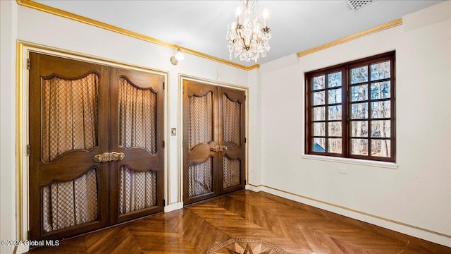 doorway to outside with dark parquet flooring, crown molding, and a chandelier