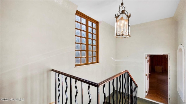 stairs featuring parquet floors and a chandelier