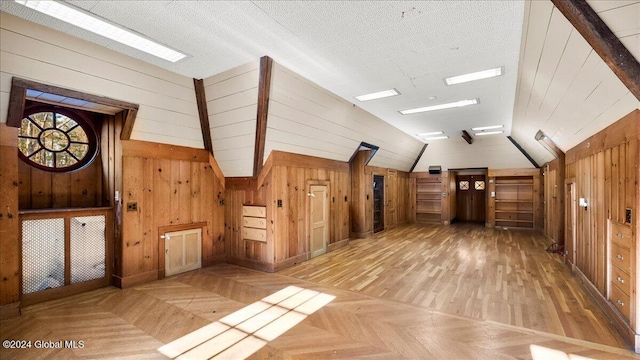 bonus room with lofted ceiling, parquet flooring, and wooden walls