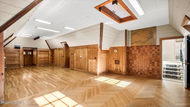 bonus room with wood walls, parquet floors, and vaulted ceiling