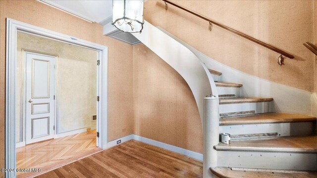 staircase featuring parquet flooring