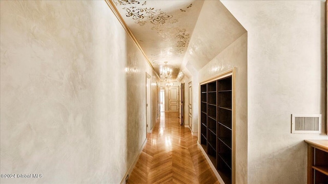 hall featuring ornamental molding, a notable chandelier, and parquet flooring