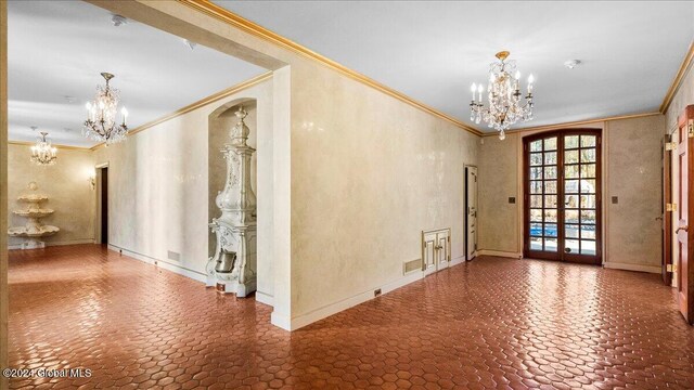 entrance foyer featuring crown molding, french doors, and an inviting chandelier