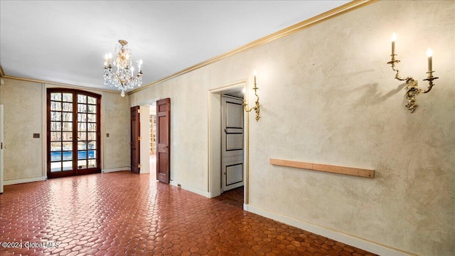 unfurnished room featuring a chandelier, french doors, and crown molding