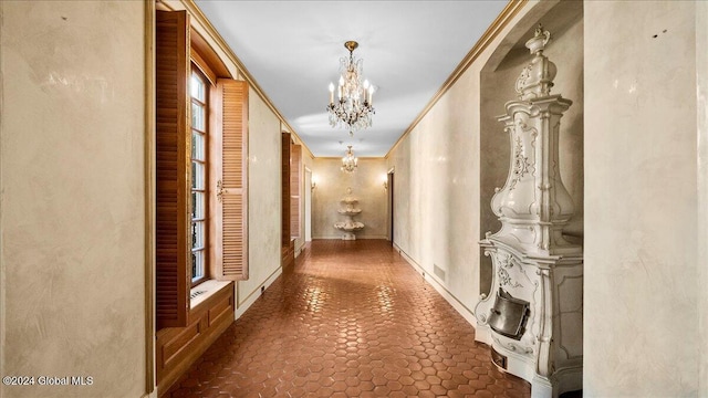 corridor featuring crown molding and a chandelier