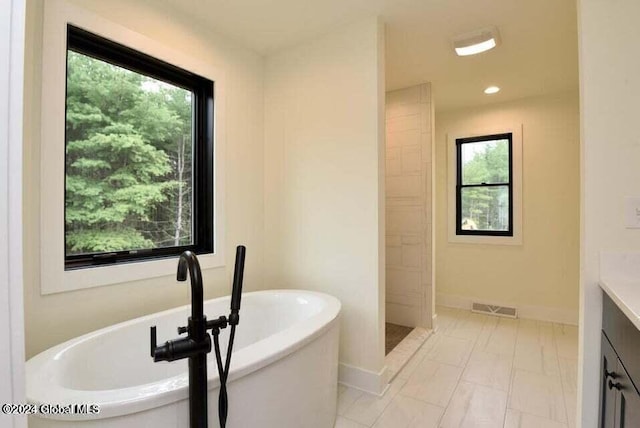 bathroom featuring shower with separate bathtub, vanity, and plenty of natural light