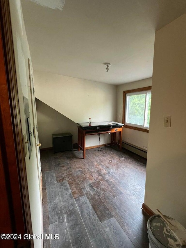 unfurnished room with dark hardwood / wood-style flooring and a baseboard heating unit