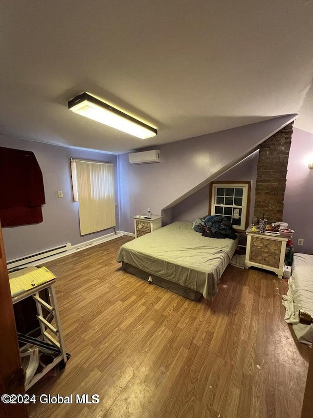 bedroom with baseboard heating, wood-type flooring, and a wall mounted air conditioner