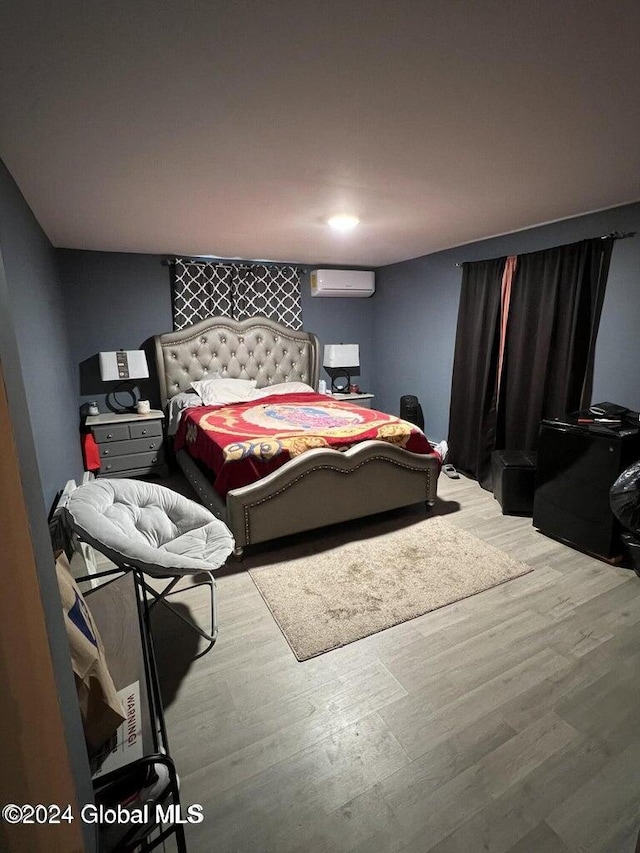 bedroom featuring light hardwood / wood-style flooring and an AC wall unit