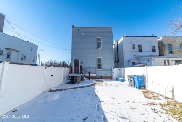 view of snow covered back of property