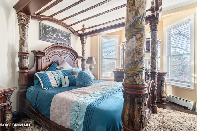 bedroom with crown molding, hardwood / wood-style flooring, and baseboard heating