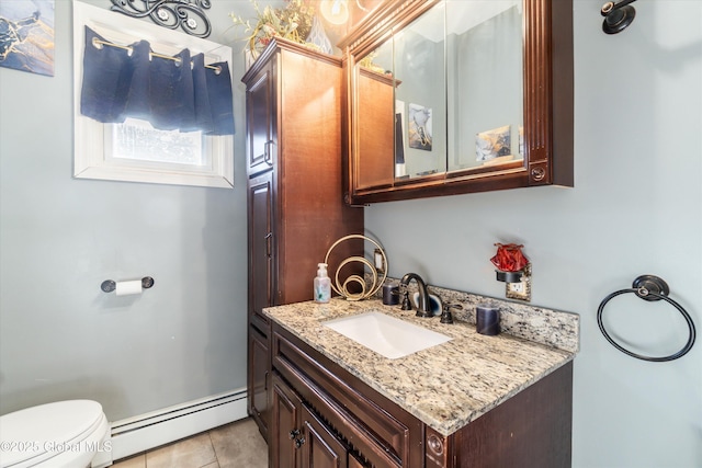 bathroom featuring tile patterned flooring, vanity, baseboard heating, and toilet