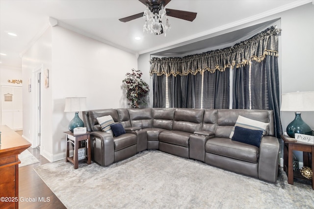 living room featuring ceiling fan, ornamental molding, and wood-type flooring