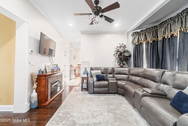 living room featuring hardwood / wood-style floors, crown molding, a tile fireplace, and ceiling fan