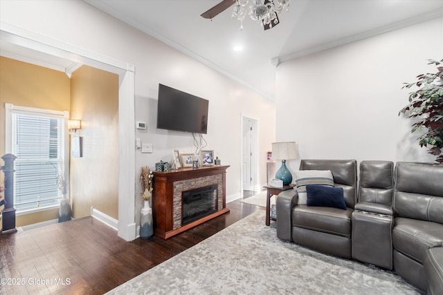 living room with dark wood-type flooring, a fireplace, crown molding, and ceiling fan