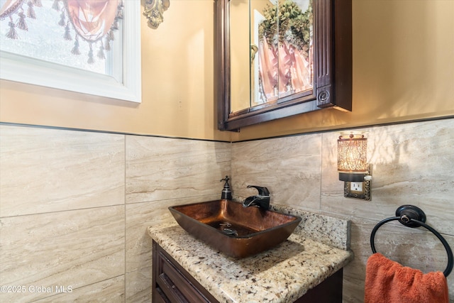 bathroom featuring vanity and tile walls