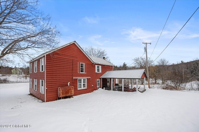 view of snow covered back of property