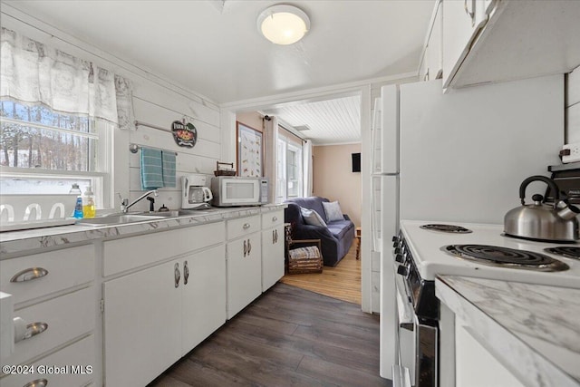 kitchen featuring white cabinetry, plenty of natural light, dark wood-type flooring, and range with electric cooktop