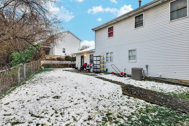 snow covered house featuring central AC