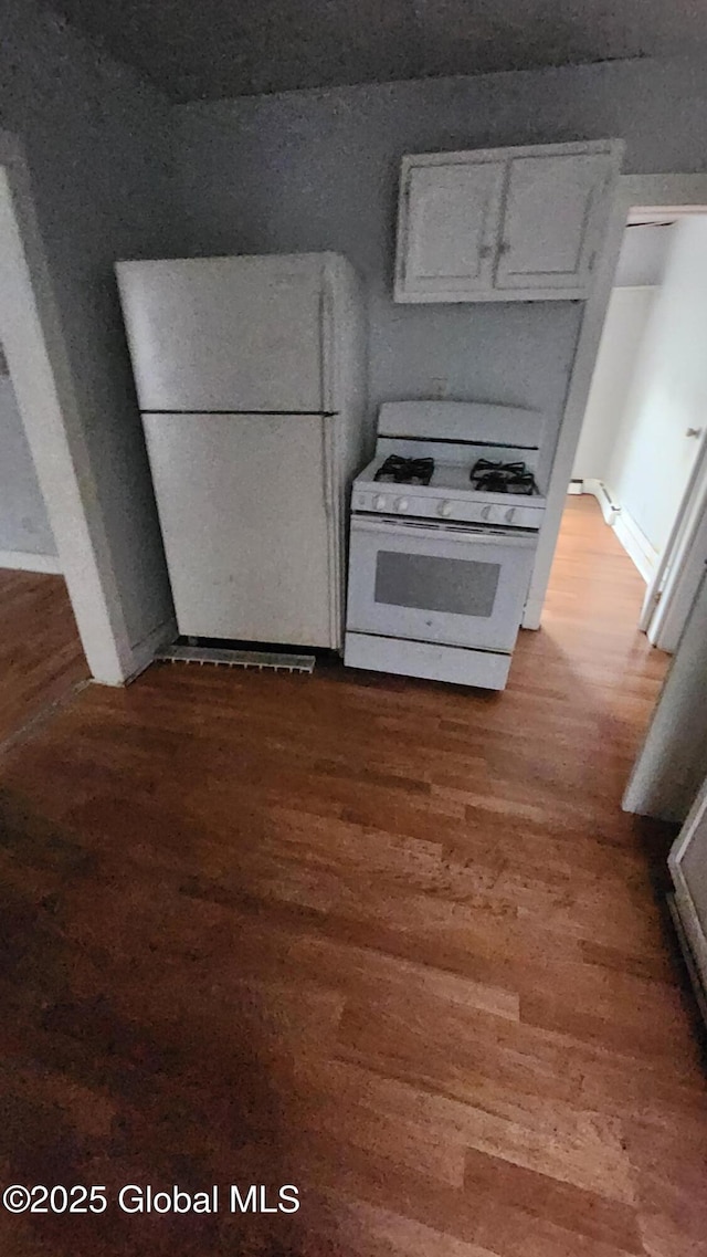 kitchen featuring white cabinetry, wood-type flooring, and white appliances