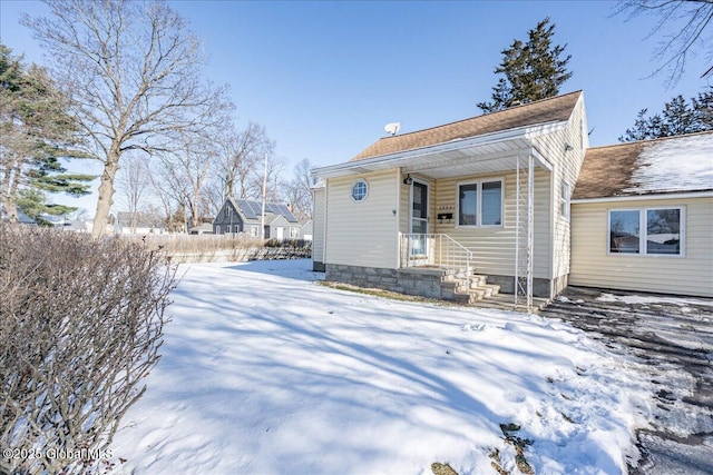 view of snow covered back of property