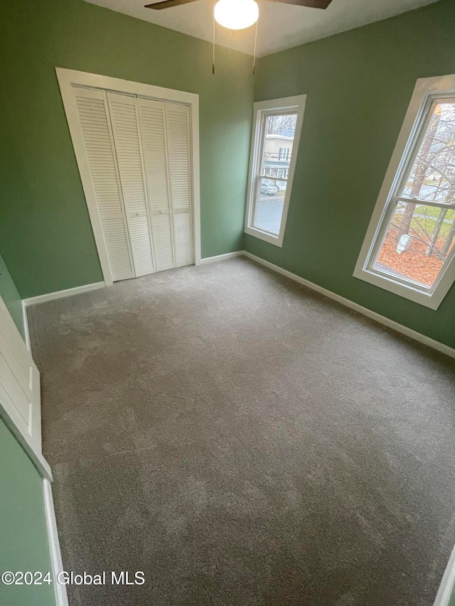 unfurnished bedroom with ceiling fan, carpet floors, and multiple windows