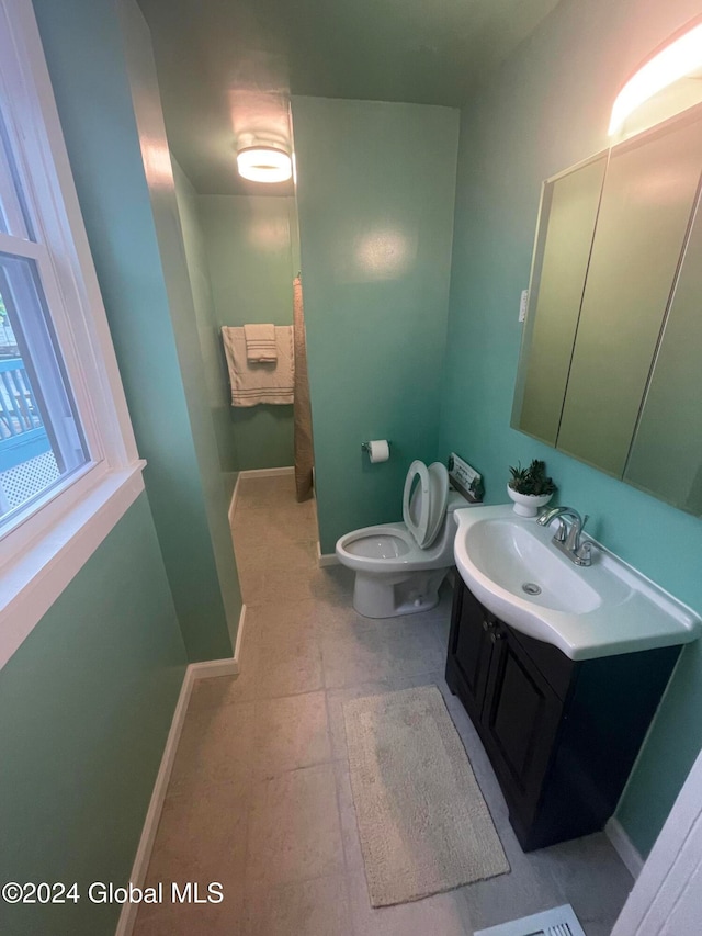 bathroom featuring toilet, vanity, and tile patterned floors