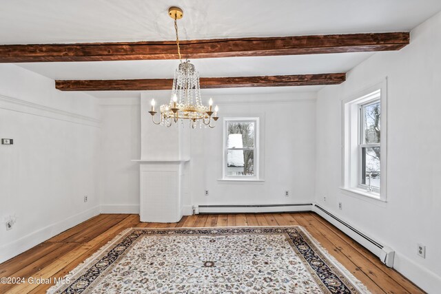 unfurnished dining area with a baseboard radiator, a chandelier, and wood-type flooring