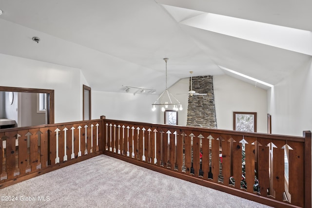 hallway featuring vaulted ceiling, track lighting, and carpet flooring