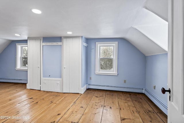 bonus room featuring a baseboard radiator, vaulted ceiling, and light wood-type flooring