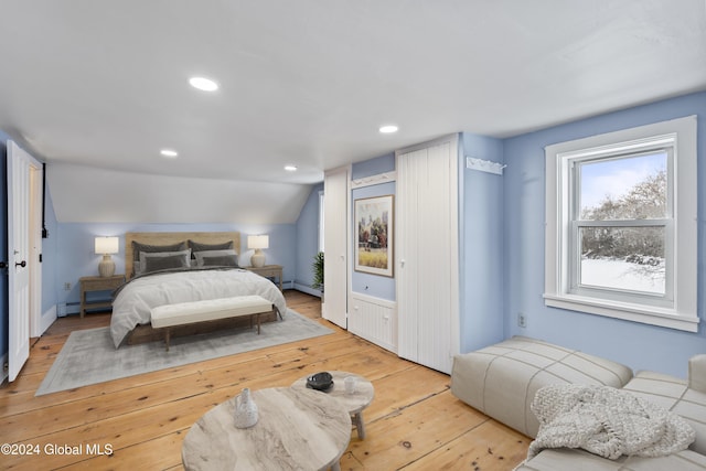 bedroom featuring vaulted ceiling, a baseboard radiator, and hardwood / wood-style floors